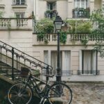 bike leaning against handrail in front of concrete building at daytime